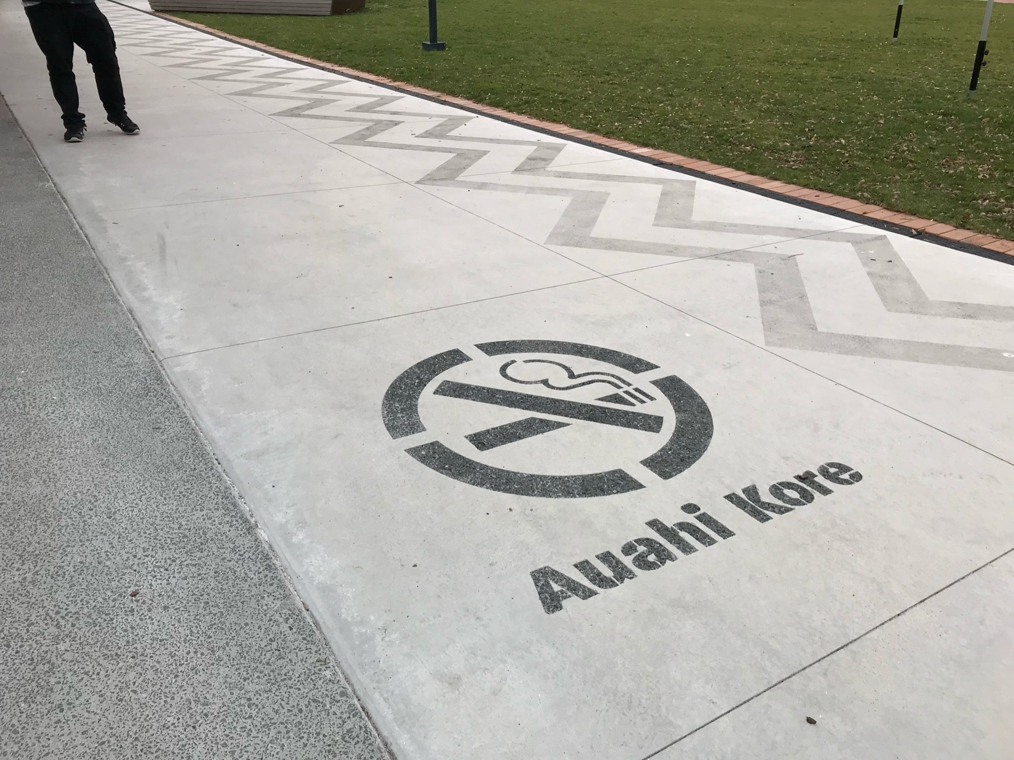 Auahi Kore sign with image of crossed out cigarette engraved into footpath