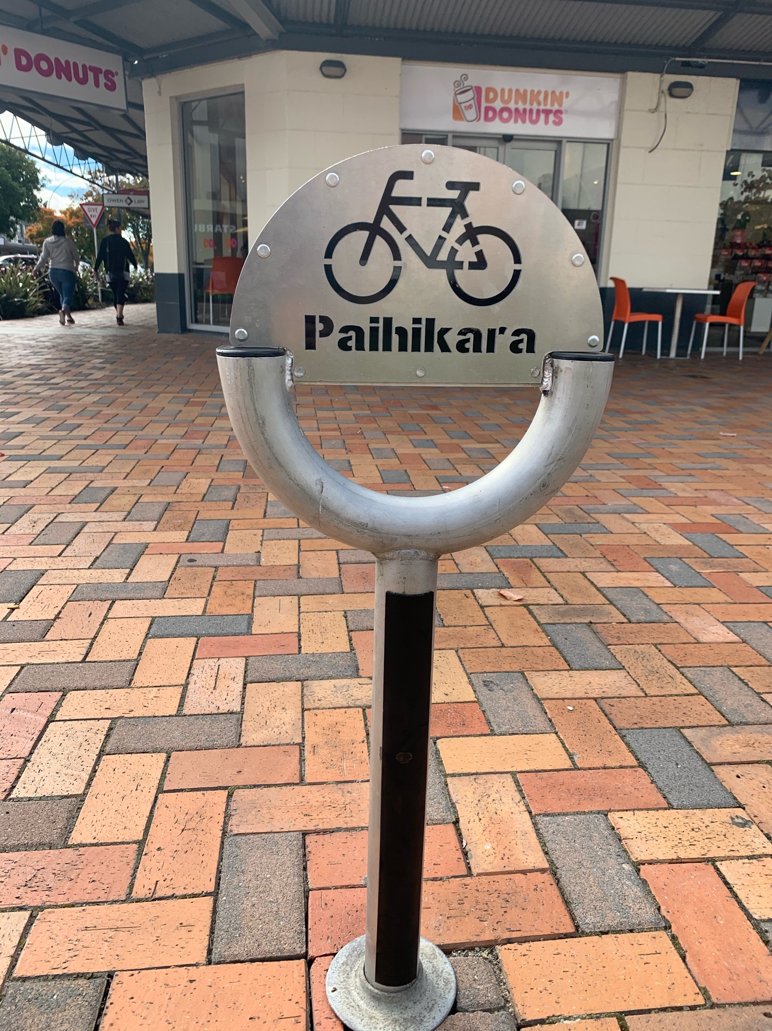 Sign of a bike stand which illustrates a bicycle with the Māori word underneath, pahikara. 